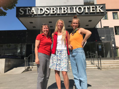 MiniBladets grundare Maria McShane står tillsammans med bibliotekarie Hedvig Andersson och reporter Nanna Salemark framför Eskilstuna stadsbibliotek.