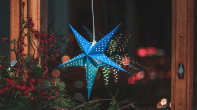 Bris blå julstjärna hänger i ett fönster