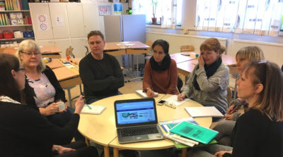 Människor som sitter vid ett runt bord