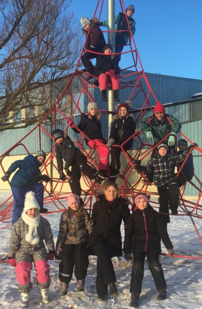 Läraren Petra sitter i skolgårdens klätterställning tillsammans med sina elever.