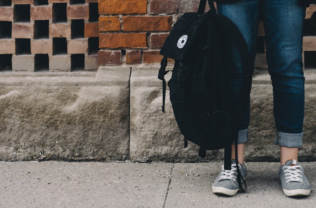 En person håller i en ryggsäck.