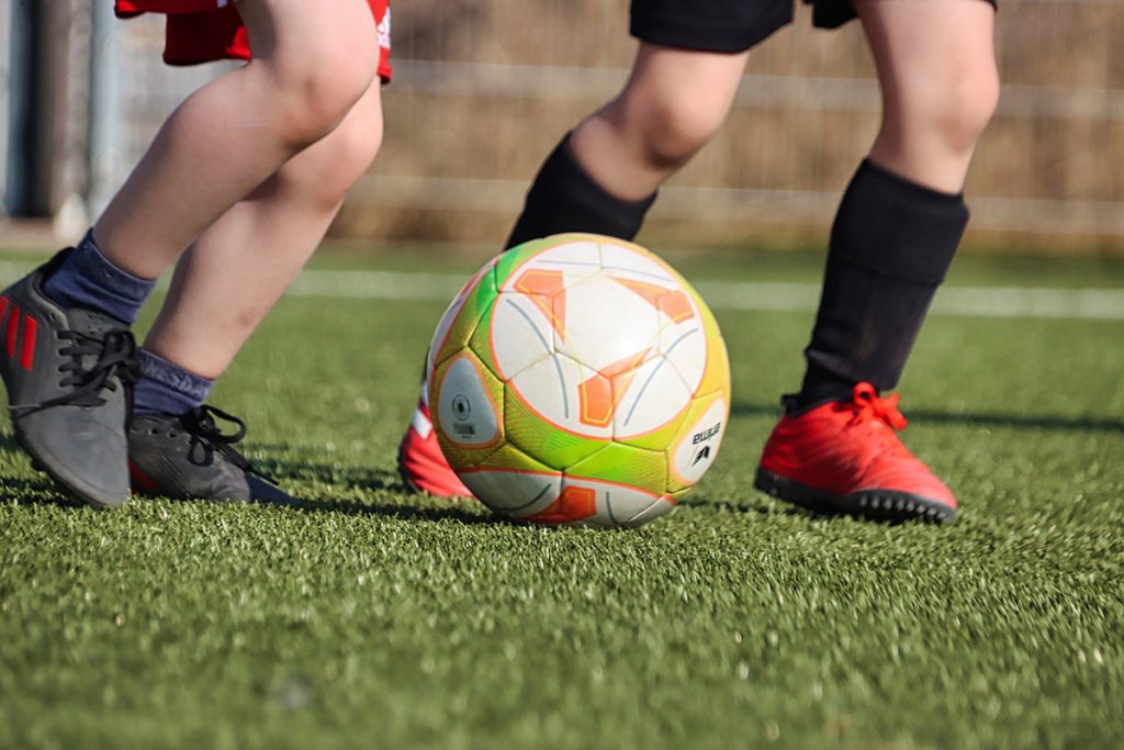 Barn som sparkar på en fotboll.